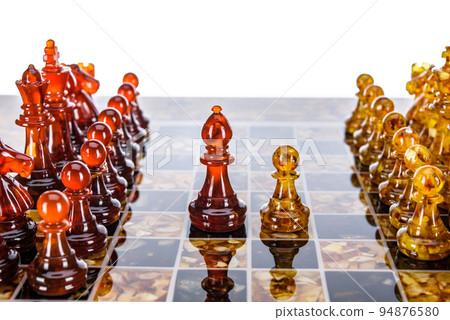 Natural amber different chess pieces figures standing on brown stone board. Close up game concept competition, Classic Gambit Tournament of confrontation. Natural amber different chess pieces figures standing on brown stone board. Close up game concept competition, Classic Gambit Tournament of confrontation. 94876580