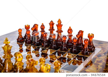 Natural amber different chess pieces figures standing on brown stone board. Close up game concept competition, Classic Gambit Tournament of confrontation. Natural amber different chess pieces figures standing on brown stone board. Close up game concept competition, Classic Gambit Tournament of confrontation. 94876584