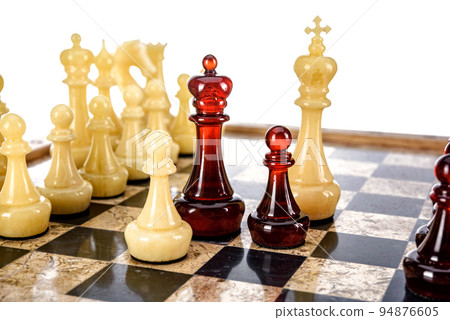 Natural amber different chess pieces figures standing on brown stone board. Close up game concept competition, Classic Gambit Tournament of confrontation. Natural amber different chess pieces figures standing on brown stone board. Close up game concept competition, Classic Gambit Tournament of confrontation. 94876605