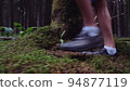 feet teen boy close-up walking on moss in the forest, close-up of the legs of a boy walking in the forest on the grass, cinematic 94877119