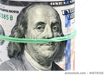 Rolled up one hundred dollar bills tied with a green rubber band Rolled up one hundred dollar bills tied with a green rubber band 94878588