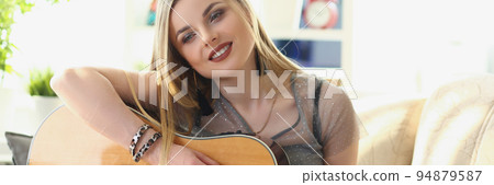 Inspired pretty woman music composer, blonde girl play on guitar 94879587