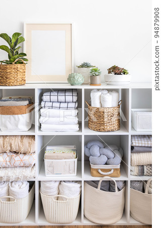 Minimalism Nordic closet shelves neatly folded bed linens and potted plants frame border copy space Minimalism Nordic closet shelves neatly folded bed linens and potted plants frame border copy space 94879908
