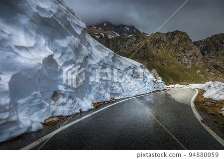 Alpine mountain road between snow at springtime, Gran Paradiso Alps, Italy Alpine mountain road between snow at springtime, Gran Paradiso Alps, Italy 94880059