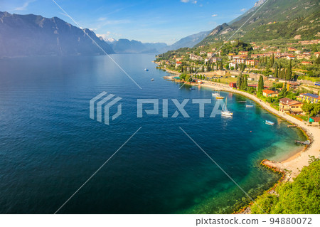 Above idyllic Lake Garda with sailboats in Malcesine at sunrise, Italian alps 94880072