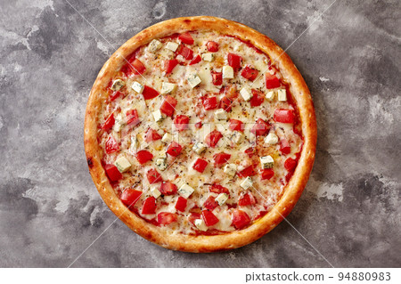 Pizza on thin dough with mozzarella, tomatoes, blue cheese and dried basil on gray stone Pizza on thin dough with mozzarella, tomatoes, blue cheese and dried basil on gray stone 94880983