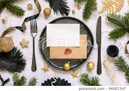 Black and golden Christmas Table setting with a card, ornaments and fir tree branches. Mockup Black and golden Christmas Table setting with a card, ornaments and fir tree branches. Mockup 94881347