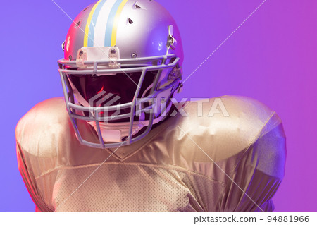 African american male american football player wearing helmet with neon blue and purple lighting African american male american football player wearing helmet with neon blue and purple lighting 94881966