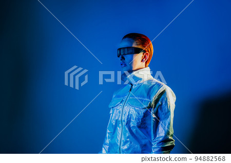 Portrait of woman, dressed in futuristic holographic clothes and glasses with reflection of matrix code in her futuristic glasses in blue light. Portrait of a cyberpunk girl. Virtual reality glasses. Portrait of woman, dressed in futuristic holographic clothes and glasses with reflection of matrix code in her futuristic glasses in blue light. Portrait of a cyberpunk girl. Virtual reality glasses. 94882568
