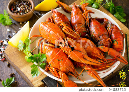 Boiled crawfish, lemon and parsley on a wooden table. Appetizer protein, the concept of healthy eating. 94882713