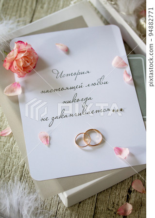 Two Golden Wedding Rings, box of chocolates and a wedding invitation, an inscription that the story of true love never ends. 94882771
