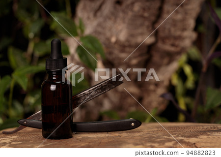 Barbershop product photography. Brown bottle and old razor Barbershop product photography. Brown bottle and old razor 94882823
