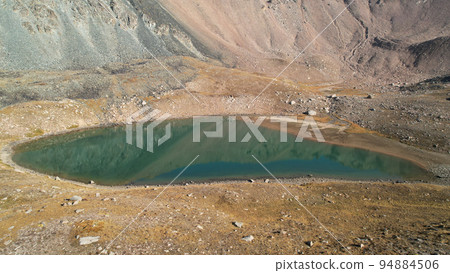 The emerald color of the water of a mountain lake The emerald color of the water of a mountain lake 94884506