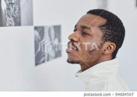 Man Looking at pictures in Gallery Closeup Man Looking at pictures in Gallery Closeup 94884507