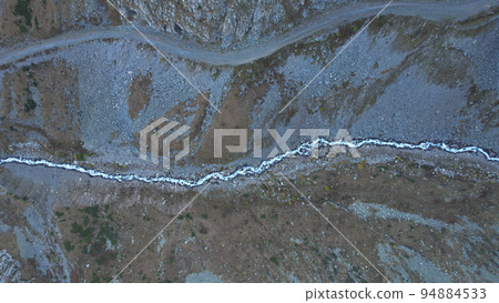 High mountains with a steep cliff and a river High mountains with a steep cliff and a river 94884533