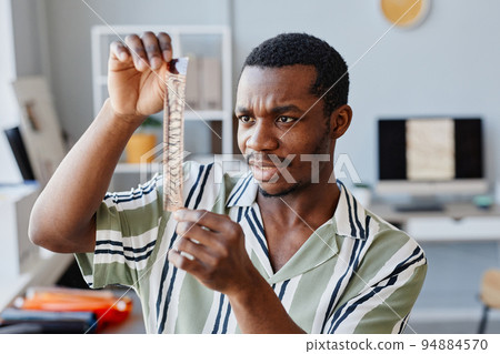 Male Photographer Looking At Film In Studio Male Photographer Looking At Film In Studio 94884570