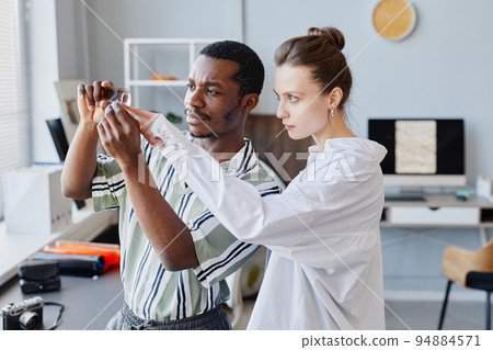 Two Photographers Looking At Film In Studio 94884571