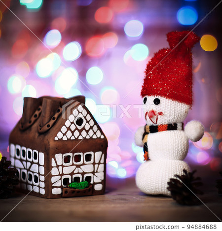 toy snowman and gingerbread house at the Christmas table toy snowman and gingerbread house at the Christmas table 94884688