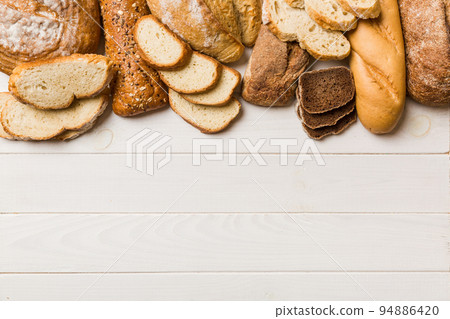 Homemade natural breads. Different kinds of fresh bread as background, top view with copy space Homemade natural breads. Different kinds of fresh bread as background, top view with copy space 94886420