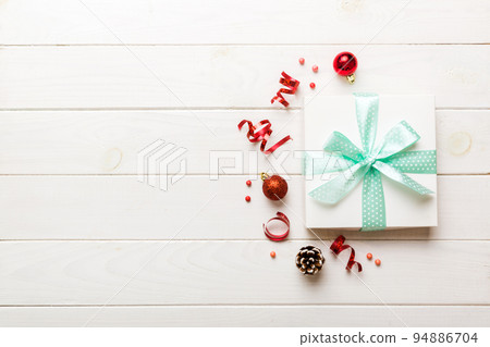 Top view Flat lay Christmas decorations and gift box on colored background with copy space. Christmas or Happy New Year composition 94886704