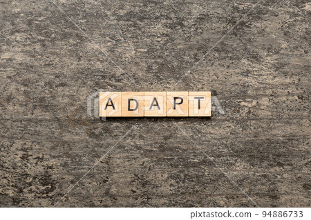ADAPT word written on wood block. ADAPT text on cement table for your desing, concept ADAPT word written on wood block. ADAPT text on cement table for your desing, concept 94886733