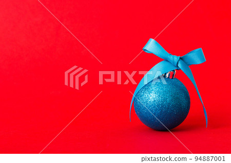 Christmas ball on colored background. decoration bauble with ribbon bow with copy space 94887001