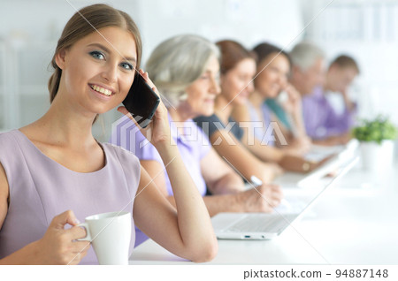 Portrait of a beautiful business girl and business team  94887148