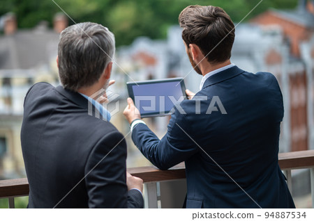Two businessmen negotioating regarding new property and looking interested 94887534