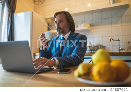 Man in blue jacket working in the home office and having a video call Man in blue jacket working in the home office and having a video call 94887621
