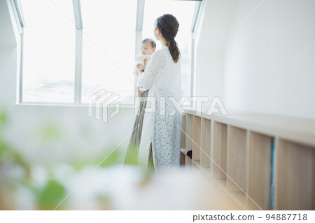A woman holding a baby 94887718
