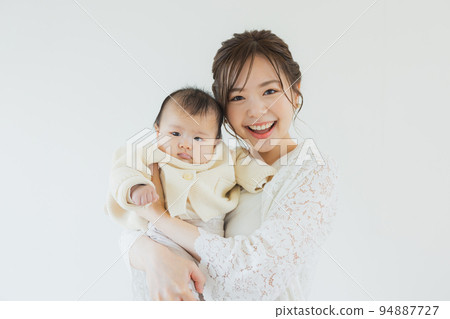 A woman holding a baby 94887727