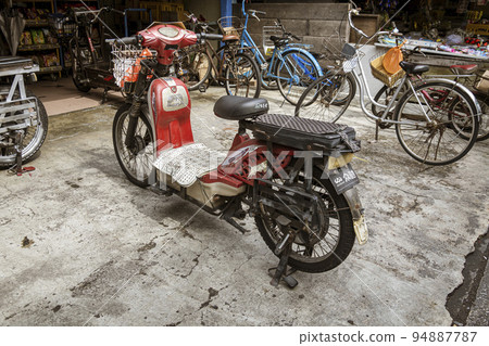 Malaysia, July 10, 2022 - Malyaisan electric motorcycle with keys in ignition on Crab Island Malaysia, July 10, 2022 - Malyaisan electric motorcycle with keys in ignition on Crab Island 94887787
