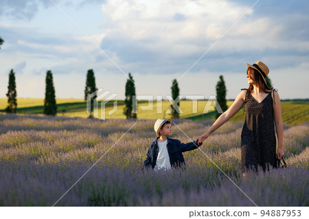 Beautiful young woman and her cute little son in the lavender field Beautiful young woman and her cute little son in the lavender field 94887953