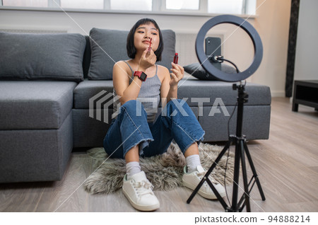 Young video blogger recording a make-up tutorial 94888214
