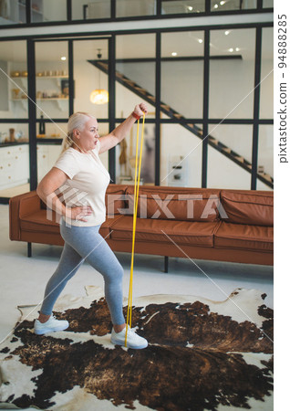 Mature plus-size woman working out at home 94888285