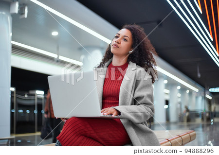 female blogger chatting with her followers while sitting on a bench in the subway. female blogger chatting with her followers while sitting on a bench in the subway. 94888296
