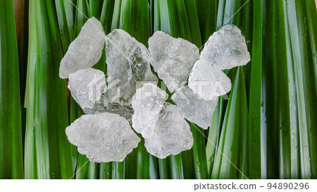 Crystal clear alum cubes or Potassium alum on green leaf Chemical compound substance Concept for beauty spa and underarm treatment industrial                       94890296