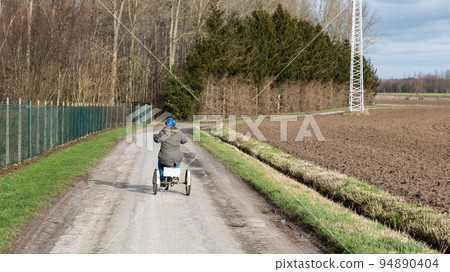 Young white woman with Down Syndrome drive a tricycle at the Belgian Countryside Young white woman with Down Syndrome drive a tricycle at the Belgian Countryside 94890404