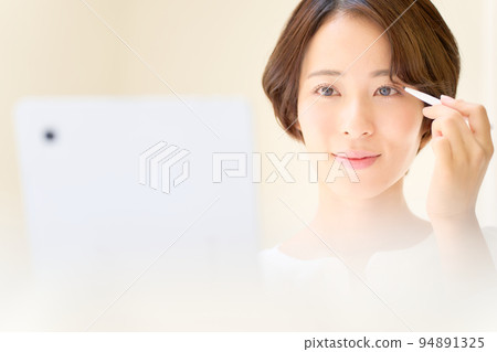 Young woman doing eye makeup beauty image 94891325