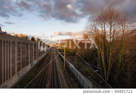 Laeken, Brussels Capital Region - Belgium - Colorful clouds over the railway tracks at the local metro stop Pannenhuis Laeken, Brussels Capital Region - Belgium - Colorful clouds over the railway tracks at the local metro stop Pannenhuis 94891721
