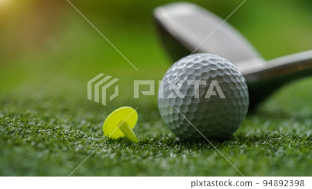 Golf club and ball in grass concept. Golf balls on the golf course with golf clubs. 94892398