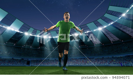 Winner emotions. Excited soccer player running at the crowded stadium with spot lights during evening football match. Concept of sport, competition, championship 94894071
