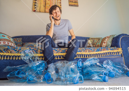 Young caucasian man hamong empty plastic bottles to recycle with sad expression Young caucasian man hamong empty plastic bottles to recycle with sad expression 94894515