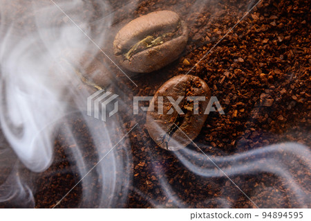 Ground coffee and coffee beans, coffee in light smoke. Ground coffee and coffee beans, coffee in light smoke. 94894595