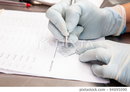 Laboratorian giving admission to pap smear samples in the laboratory for analysis. Scientist receiving patient samples for laboratory for analysis. Cervical cancer concept. Medical concept. Laboratorian giving admission to pap smear samples in the laboratory for analysis. Scientist receiving patient samples for laboratory for analysis. Cervical cancer concept. Medical concept. 94895090