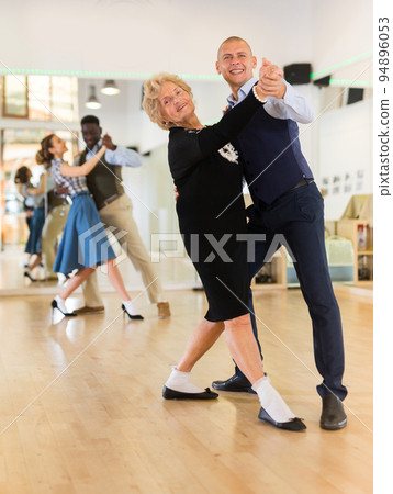 Man and senior woman dancing waltz in studio Man and senior woman dancing waltz in studio 94896053