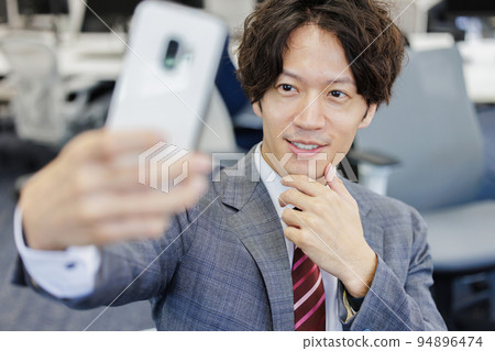 A man taking a selfie with a smartphone A man taking a selfie with a smartphone 94896474