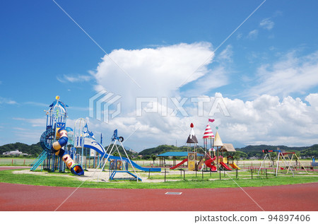 明亮清爽的夏日公園風景，配有色彩繽紛的遊樂設備 94897406