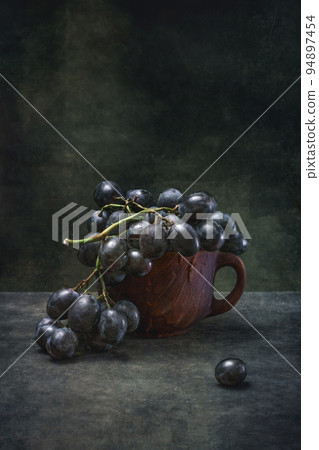 Still life with ripe grapes in a brown cup 94897454