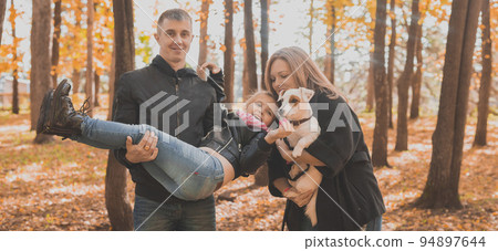 Family spend time in autumn park with a dog. Father, mother and daughter and jack russell terrier dog having fun in fall Family spend time in autumn park with a dog. Father, mother and daughter and jack russell terrier dog having fun in fall 94897644